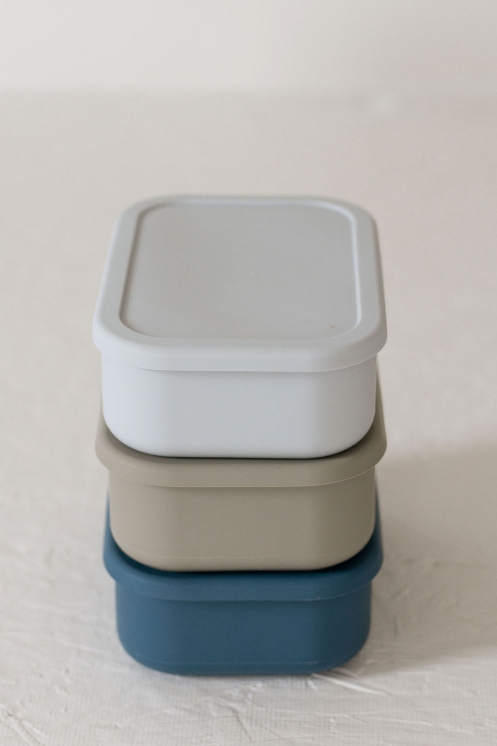 Set of divided plates and lids in various colors on a light surface